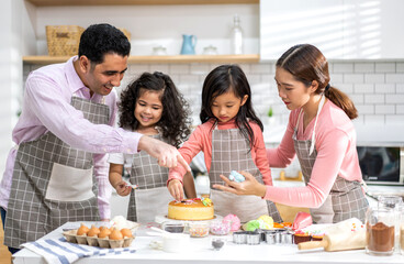 Portrait of enjoy happy love asian family father and mother with little asian girl daughter child play and having fun cooking food together with baking cookie and cake ingredient in kitchen