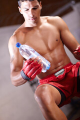 Naklejka premium Boxing, man and bottle of water in gym for health, rest and energy from workout, fitness challenge and training for fight. Strong boxer drinking liquid for hydration, nutrition and power for exercise