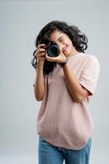 Young woman with professional camera isolated on background