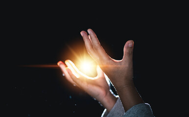 Hands folded in prayer in church. Concept for faith, spirituality and religion. Woman praying in the morning have Yellow lights and sparkles coming. Christian life crisis prayer to god. - obrazy, fototapety, plakaty