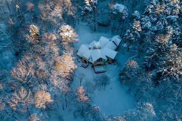 Aerial view of an old manor house hidden among a fabulous snow-covered forest in winter. The Turliki estate of 1901 - dacha Morozovoy. Obninsk, Russia