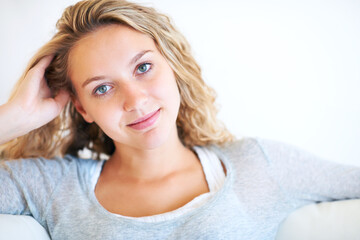 Woman, portrait and relax on sofa in home for peace, slow morning or comfortable weekend. Female person, face and soft smile confidence or calm feminine on couch in apartment for rest, lazy in Canada