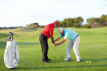 Golf training, help and men with a game on a field for a competition, showing or support. Fitness,...