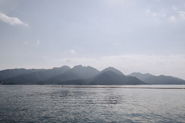 Mountains and water view from the ferry to Miyajima (Miyajimacho) Island. 