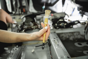 Worker make dry cleaning the car interior using a special brush with foam