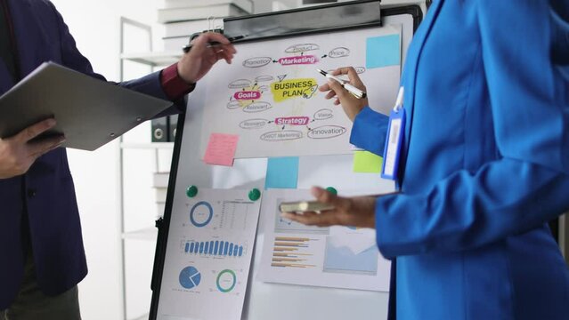 Small group of young businessman meeting startup business partners, analyzing business plan strategies and presenting, exchanging opinions of colleagues.