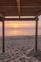 Wooden lifeguard walkways on the beach shore at sunrise