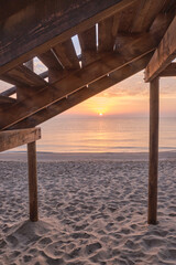 Wooden lifeguard walkways on the beach shore at sunrise