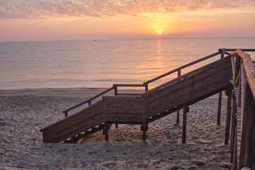 Wooden lifeguard walkways on the beach shore at sunrise