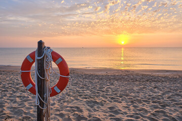 Post with lifeguard float on the beach shore