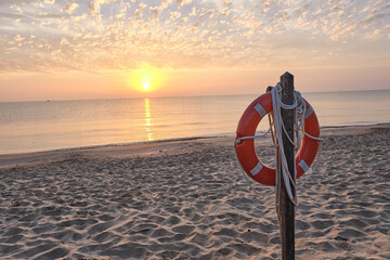 Post with lifeguard float on the beach shore