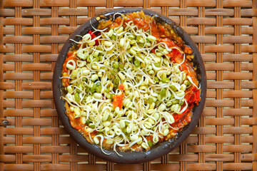 Indonesian sambal consists of chilies, onions, tomatoes, shrimp paste on an earthen plate.