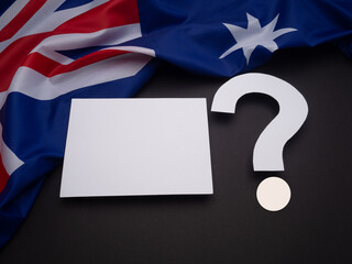 Part of the Australia flag with a blank white paper and a question mark is on a black background.