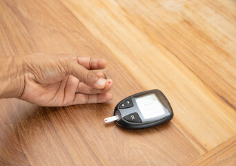 Blood drop on finger for checking blood sugar level with glucometer.