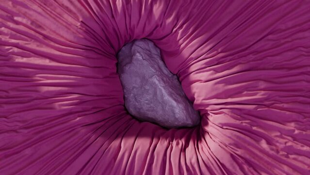 Stone sinking into purple fabric