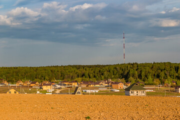 A distant view of a village under construction with similar houses in the countryside