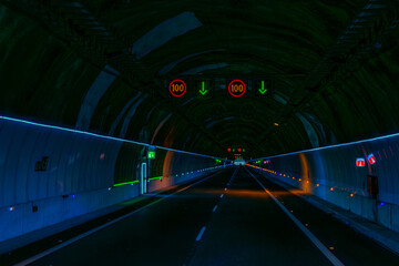 Illuminated signs of maximum speed allowed 100 km/h inside a highway tunnel.