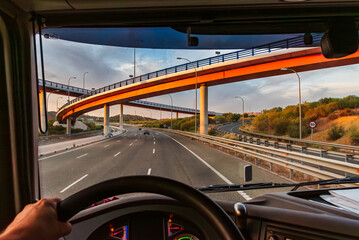 View from the driving position of a truck of a highway with several bridges at different levels,...