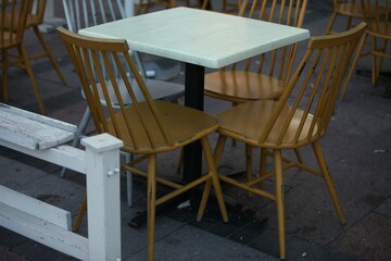 Fototapeta na wymiar Yellow and white chairs and tables in the cafe outside, retro style
