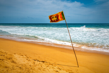 Sri Lankan flag waving over a beach sand. Sri Lanka.
