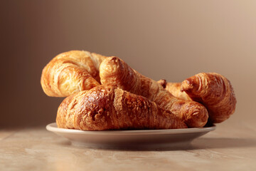 Freshly baked croissants on a beige ceramic table.