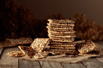 Crackers with sunflower and flax seeds on an old wooden table.