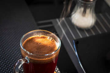 Shot of the hot coffee in the transparent cup. Beverage