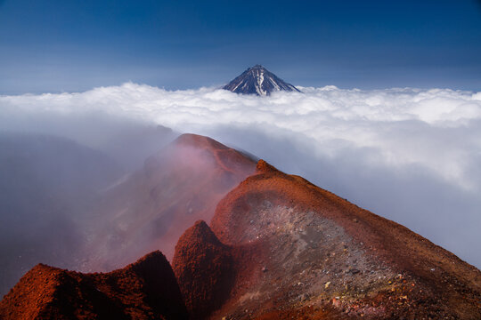 Kamchatka volcanic landscape: view to top of cone of Koryaksky Volcano from scenery active crater of Avacha Volcano on sunny day and blue sky. Russian Far East