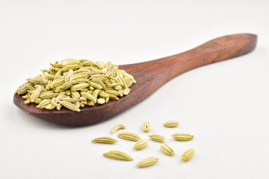 closeup of fennel seeds in spoon on white background