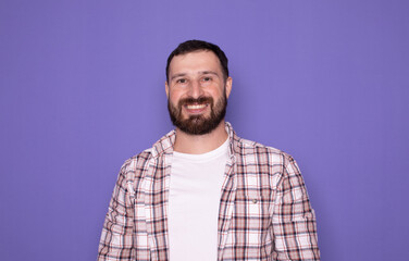 Young handsome bearded man over isolated purple background happy and smiling. 