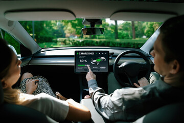Electric car driver checks battery charging status, range and charging limit on app screen in the...