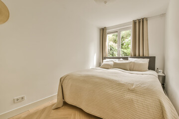 a bedroom with white walls and wood flooring in the middle of the room, there is a large bed on the right side