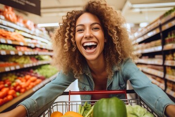A cheerful and smiling woman customer pushing a shopping cart filled with fresh groceries down the supermarket aisle, the joy of products shopping. - 666012604