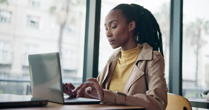 Serious black woman typing on laptop in cafe, remote work and reading email on internet, web or search. Computer, freelance and copywriter in coffee shop, store or restaurant, writing blog or article