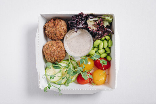 bowl in Chinese style.meatballs with beans, herbs, cherry tomatoes and sauce in a container top view