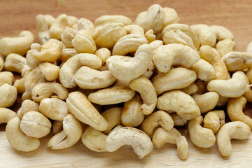 Cashew nuts on cutting board on white background.