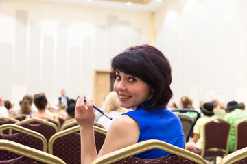 A woman general meeting of the enterprise team. Woman sitting in a hall with many people listening...