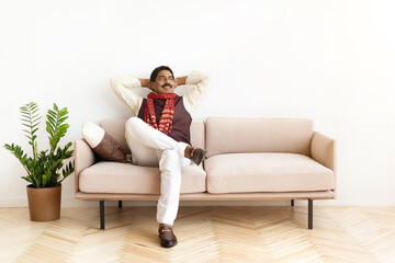 Smiling mature indian man in traditional clothes relaxing at home