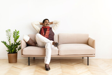 Obraz premium Smiling mature indian man in traditional clothes relaxing at home