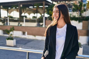 Fototapeta premium Young beautiful hispanic woman smiling confident looking to the side at street