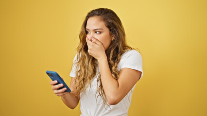 Young beautiful hispanic woman using smartphone with worried expression over isolated yellow background