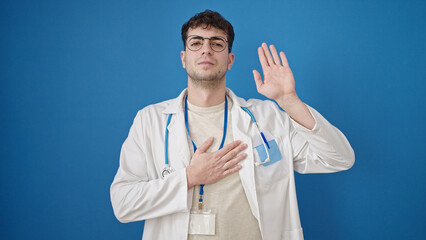 Young hispanic man doctor making an oath with hand on chest over isolated blue background