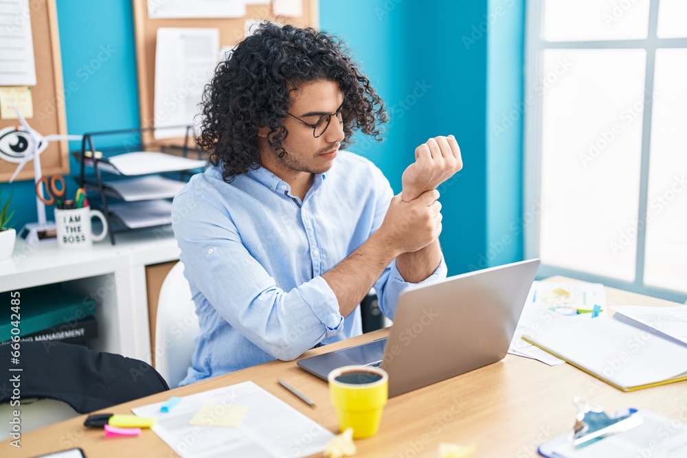 Sticker Young latin man business worker suffering for wrist pain working at office