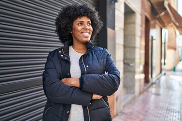 African american woman standing with arms crossed gesture at street