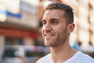 Young caucasian man smiling confident looking to the side at street