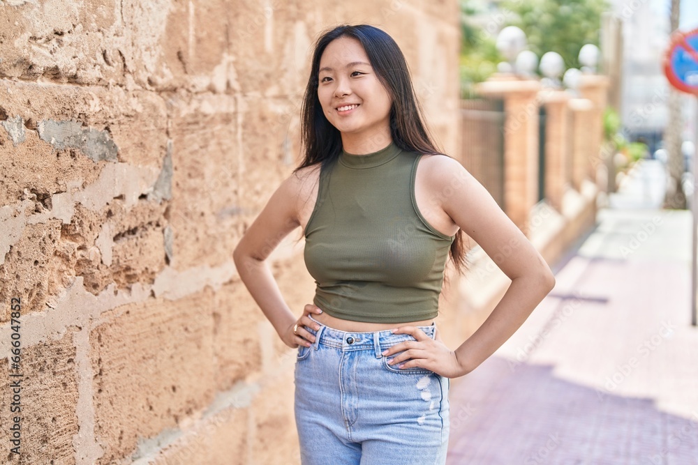 Poster Young chinese woman smiling confident looking to the side at street