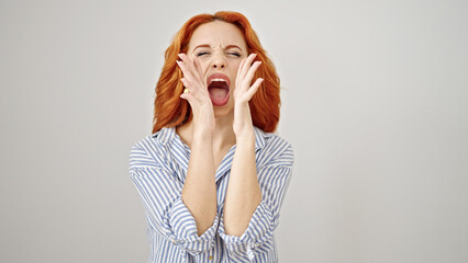 Young redhead woman screaming loudly over isolated white background
