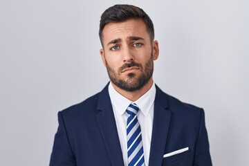 Handsome hispanic man wearing suit and tie looking sleepy and tired, exhausted for fatigue and hangover, lazy eyes in the morning.