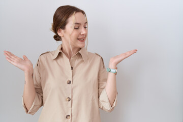 Young caucasian woman wearing casual shirt smiling showing both hands open palms, presenting and...