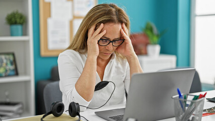 Middle age hispanic woman business worker stressed using laptop at the office